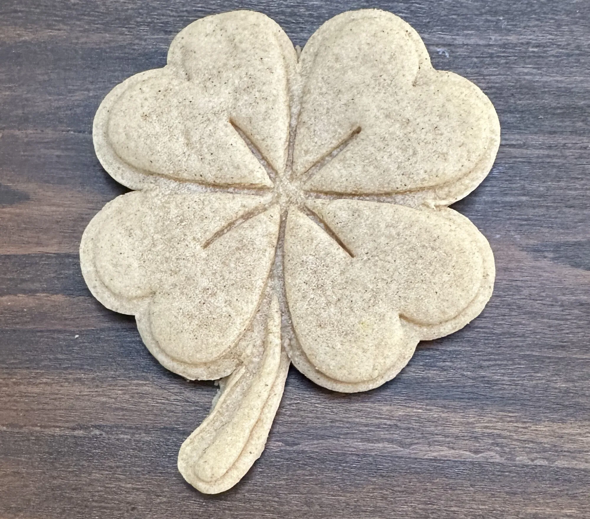 Plain stamped shamrock cookie on natural sugar cookie dough